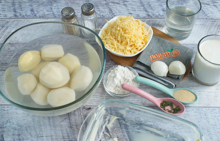 1. Этап. Запеченная картошка с сыром чеддер: Духовку разогрейте до 220ºС (428 ºF) . Форму для выпечки (20х20 см) смажьте маслом. Подготовьте необходимые продукты. Овощи помойте, очистите. Сыр натрите на крупной терке.