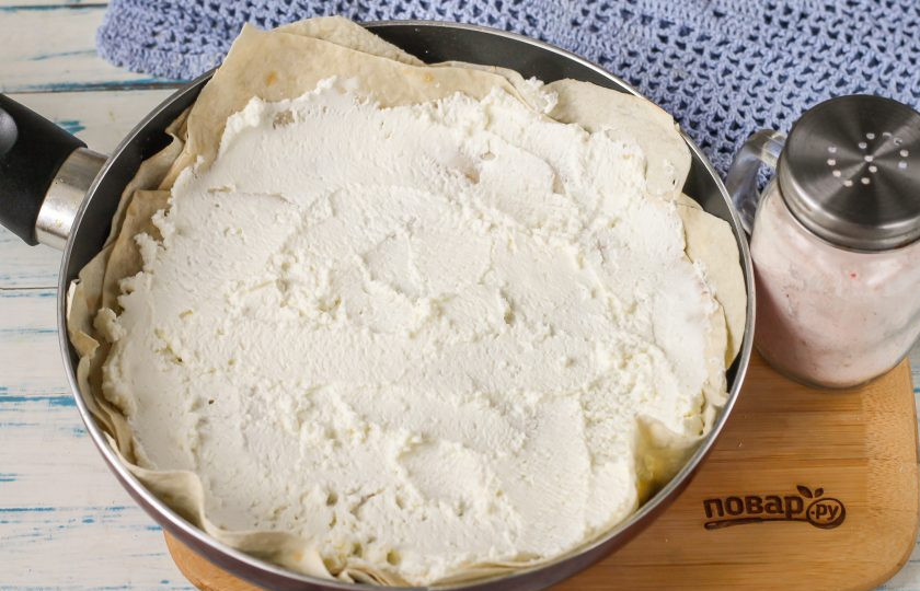 1. Этап. Пирог из лаваша на сковороде: Накройте вторым кругом, затем присыпьте еще сыром. Третий круг обмажьте творогом любой жирности и присолите его.