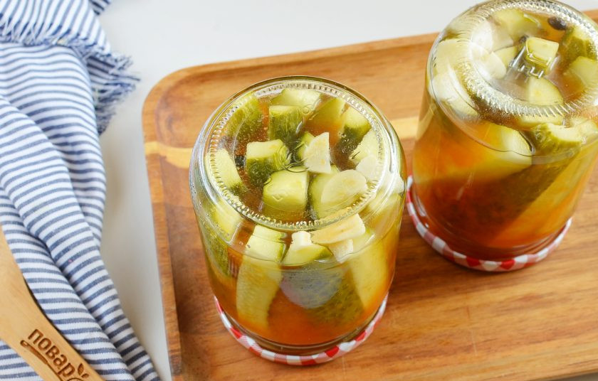 1. Этап. Огурцы в томатном соусе: Достаньте банки из кастрюли, закрутите плотно крышками. Переверните вверх дном и оставьте остывать в таком виде.