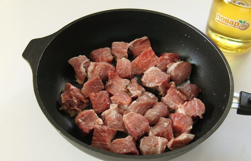 1. Этап. Суп Охотничий: Налейте в кастрюлю или казан воду и поставьте на огонь. Тем временем мясо нарежьте небольшими кусочками и обжарьте на сковороде на сильном огне с добавлением соли и специй.