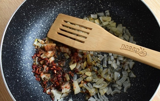 1. Этап. Гуляш Восхитительный: Разогрейте на сковороде масло, пассеруйте измельченные лук и чеснок до мягкости. Добавьте острый перец, сладкую паприку и розмарин, перемешайте.