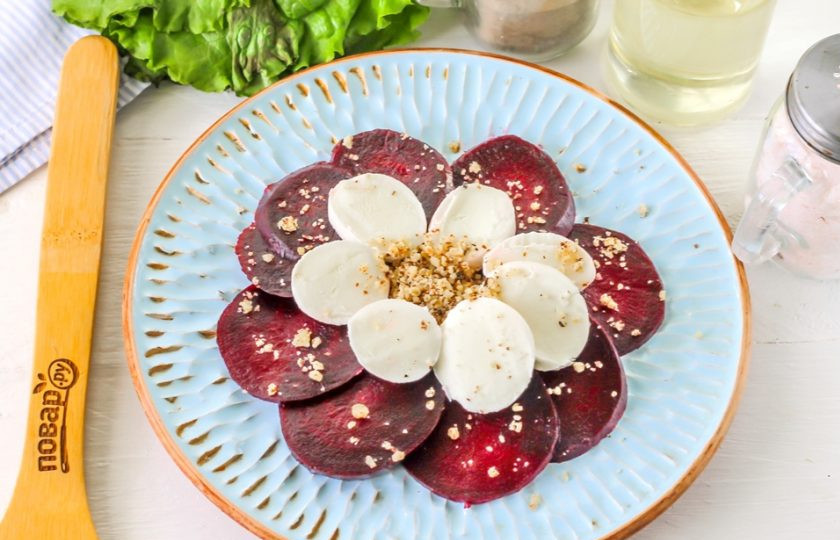 1. Этап. Карпаччо из свеклы: Ореховую крошку соедините в пиале с небольшим количеством растительного масла и спрессованным, очищенным зубчиком чеснока. Перемешайте и выложите на нарезки в любом порядке.