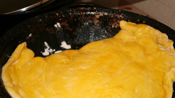 1. Этап. Пирог с творогом и зеленью: 5. Выложить пирог с творогом и зеленью в домашних условиях на противень или в форму для запекания. Смазать желтком, чтобы корочка получилась румяной.