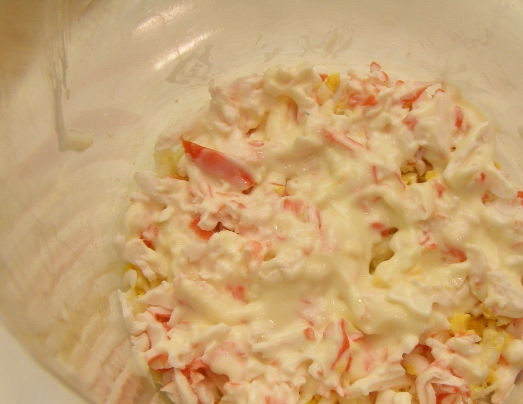 1. Этап. Салат Любимый с черносливом: Крабовые палочки тоже натрите на тёрке. Первым слоем в салатнице будет одно тёртое яйцо, вторым - четверть крабовых палочек и смажьте майонезом.