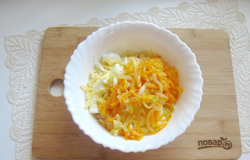 1. Этап. Салат Балтийский: Твердый сыр натрите на терке. Выложите в салатник, добавьте лук с морковью.