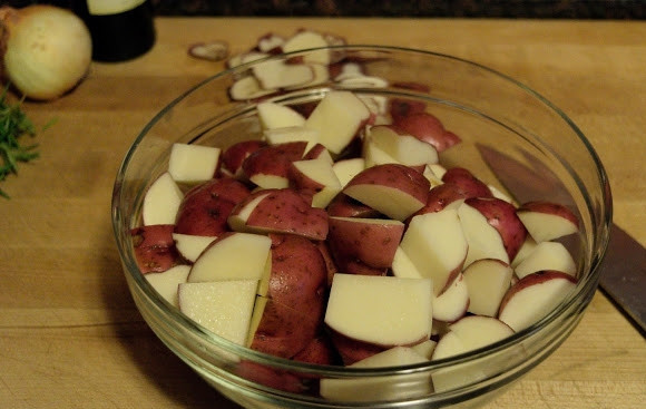 1. Этап. Запеченный картофель с чесноком и розмарином: 1. Картофель тщательно вымойте (молодой можно не чистить!) и нарежьте небольшими кусочками. Выложите в глубокую мисочку.