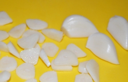 1. Этап. Кролик, тушенный в вине с овощами: Очищаем зубчики чеснока, половину нарезаем тонкими пластинками, вторую половину измельчим чеснокодавкой.