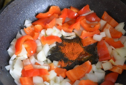 1. Этап. Люля-кебаб из индейки с пикантным соусом: Берём сковороду или сотейник, нагреваем, наливаем масло, кладём перец, лук и чеснок, на среднем огне обжариваем 5 минут. Далее добавляем паприку. Паприка непременно должна попасть на растительное масло, тогда она раскроет свой вкус и аромат.