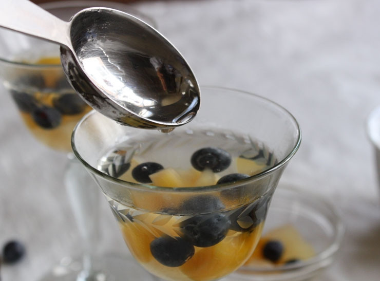 1. Этап. Желатин (десерт): Добавьте в жидкость сахар и по желанию ванильный экстракт. Дайте сахару раствориться. В порционные пиалы положите чернику и кусочки мандаринов. Залейте их желе.