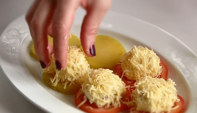 1. Этап. Простая закуска из сельди: 6. Из творожной массы руками сформируйте шарики, обваляйте их в мелко натертом сыре и выложите по одному на картофель и помидор.