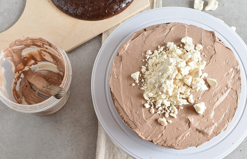 1. Этап. Торт в мультиварке: Выложите сверху второй корж, намажьте вторую половину сметанного крема и посыпьте разломанными меренгами.