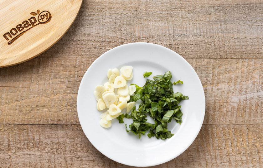 1. Этап. Салат из огурцов с базиликом на зиму: Листья базилика промойте, отделите от веточек и мелко нарежьте. Чеснок очистите и нарежьте.