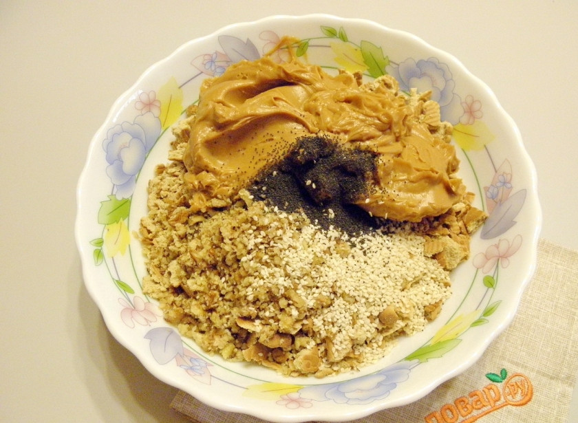 1. Этап. Торт Муравейник из печенья со сгущенкой: К печенью добавьте полученный крем из сгущенки и масла, также измельченные грецкие орехи, мак, кунжут. Часть орехов, мака и кунжута оставьте для украшения тортика.