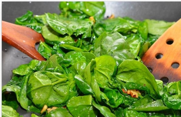 1. Этап. Салат из шпината, изюма и кедровых орешков: Следом за орешками кладем в сковороду шпинат. Перемешивая, тушим около 1 минуты, максимум - 2 минуты. Нам нужен слегка размякший шпинат - для этого достаточно 1 минуты на сковороде.