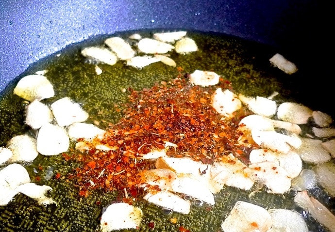 1. Этап. Спагетти с чесноком и петрушкой: 7. Добавьте в сковороду хлопья красного перца.