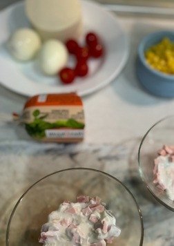 1. Этап. Салат Лёгкость: Собираем салат порционно в креманках. Первым слоем выкладываем ветчину нарезанную кубиком, добавляем немного йогуртовой заправки