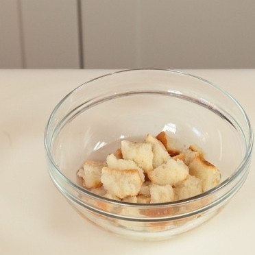 1. Этап. Жареные фрикадельки: Замочите хлеб в воде, пока он не станет очень мягким, затем отожмите его от лишней жидкости.