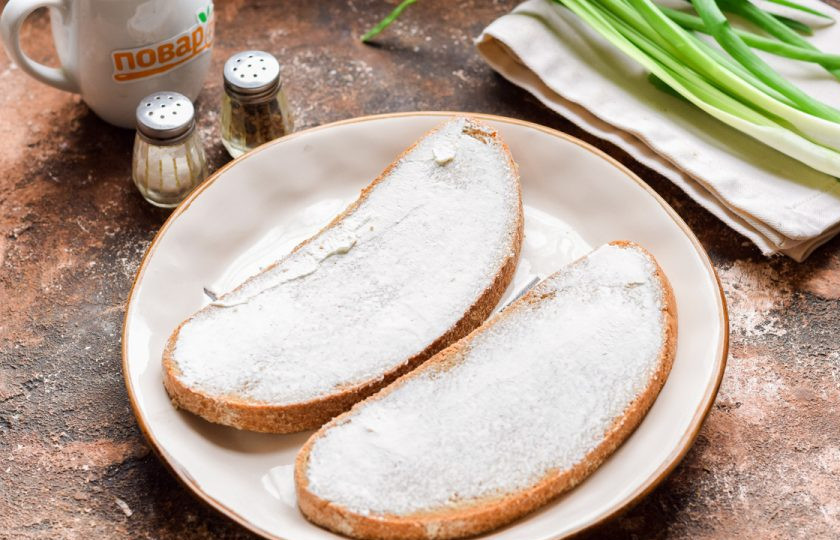 1. Этап. Бутерброды с баклажанами и помидорами: Ломтики любимого хлеба смажьте сливочным сыром.