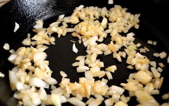 1. Этап. Паэлья с курицей и горошком: 2. На той же сковороде обжарьте предварительно очищенный и измельчённый лук.