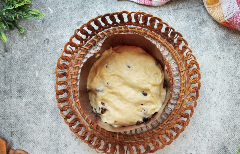 1. Этап. Кулич с шоколадной начинкой: В тесто добавьте просушенный изюм и перемешайте, обминая. Тесто снова накройте и дайте ему подойти еще в течение 30 минут. Разделите тесто на части, сформируйте шар и выложите части в формочки на 1/3 высоты.