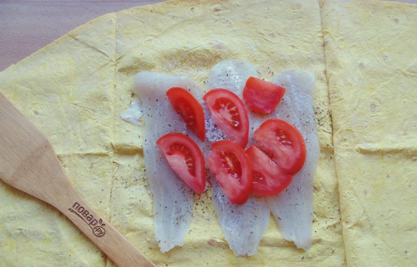 1. Этап. Судак запеченный в лаваше: Помидор нарежьте произвольно и выложите на рыбу.