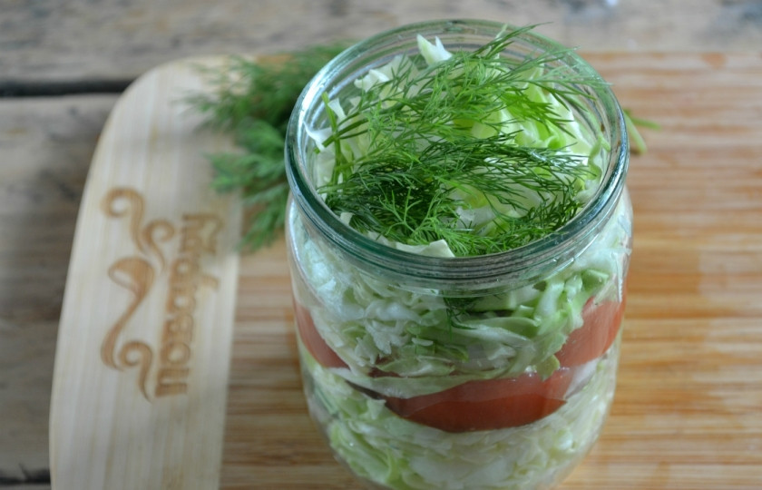 1. Этап. Маринованная капуста с помидорами: На дно подготовленной банки сложите перец горошком и лавровые листья, затем — половину капусты, помидоры и снова капусту. Сверху положите пару веточек укропа.