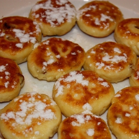 1. Этап. Сырники с изюмом (без яиц): Посыпаем сырники сахарной пудрой - и подаем к столу в горячем виде. Готово!