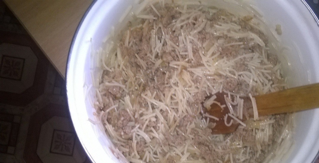 1. Stage. Casserole Pomogalochka: Add onion and meat roast to the noodles. Stir.