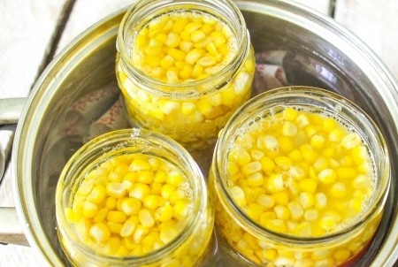 1. Stage. Canned corn: Fill each jar with water to the base of the neck. Put the pan on the fire, cover the jars with lids and sterilize after boiling over medium heat for about an hour. Before sterilization is completed, pour vinegar into the cans; 1 tbsp. Can of 0.5 l. l vinegar.