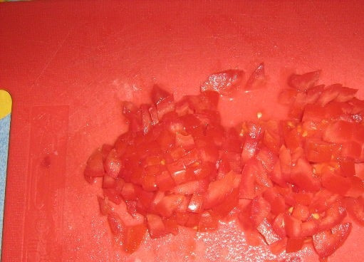 1. Этап. Долма азербайджанская: 3. Подготовьте помидоры. Помойте, освободите от плодоножки. Затем нарежьте на небольшие кусочки.