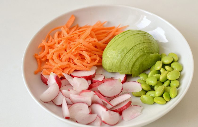 1. Этап. Поке боул: Нарежьте редис четвертинками, авокадо тонкими ломтиками, морковь натрите на терке, а эдамаме очистите от стручков.