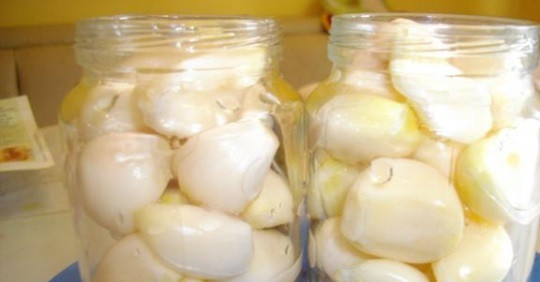 1. Этап. Закуска из чеснока на зиму: 3. Рецепт дан на две банки, поэтому в каждую кладем по одной лаврушке, гвоздичке, и по четыре перчинки. Плотно напихаем банку чесноком.