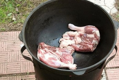 1. Этап. Утка, тушенная с картошкой в казане: Нагреваем казан и выкладываем в него куски утиного мяса кожей вниз.