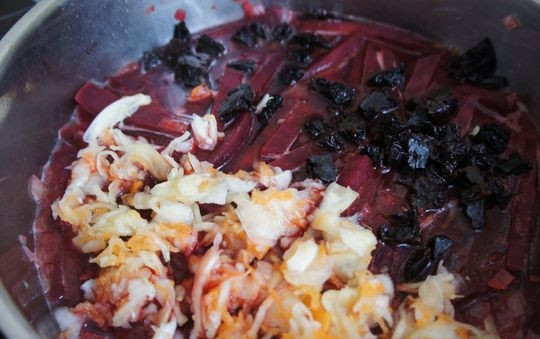 1. Этап. Тушеная свекла с черносливом: 4. Возьмите чернослив, мелко нарежьте и добавьте в сковородку, туда же положите капусту. Перемешайте и тушите еще минут 10.