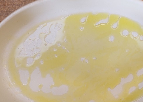 1. Этап. Фаршированные конкильони с курицей: Смазываем форму для запекания оливковым маслом и слегка присыпаем мукой.