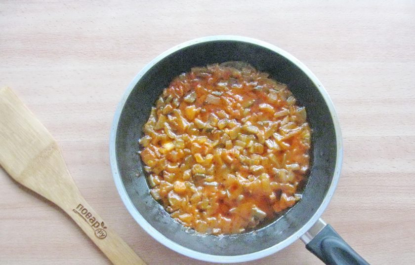 1. Этап. Солянка из судака: Налейте в сковороду подсолнечное масло и 50 мл. воды. Накройте крышкой и тушите лук с огурцом и томатной пастой на среднем огне 10-12 минут.