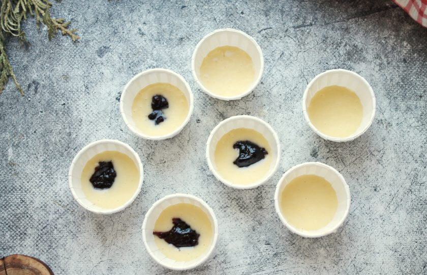 1. Этап. Кексы с вареньем: В формочки для кексов налейте тесто на 1/3 высоты и положите в каждую часть варенья.