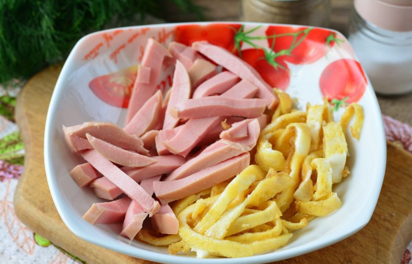 1. Этап. Салат из омлета и колбасы: Всыпьте в миску омлет и колбасу.