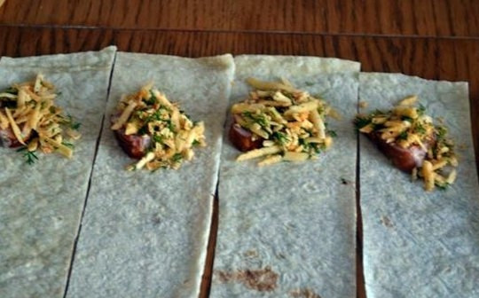 1. Этап. Треугольники из лаваша с сыром: Поверх колбаски выкладываем ложку начинки из сыра.