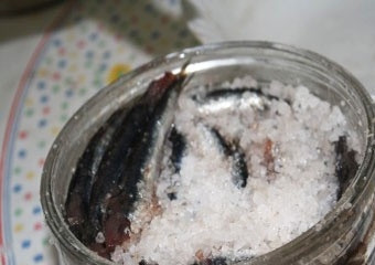 1. Этап. Засолка хамсы: 6. Сверху, когда емкость уже полная, щедро присыпьте солью. Установите на первые сутки небольшой груз сверху, накрыв верхний слой соли кусочком чистой марли.