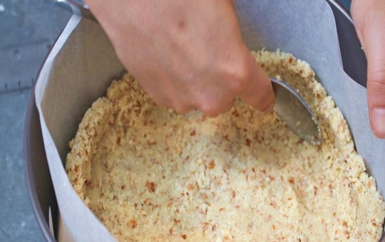 1. Этап. Чизкейк без сахара: Разъемную форму для выпечки (диаметром 22 см) покройте бумагой для выпечки, смажьте бумагу маслом. Выложите смесь для основы и утрамбуйте, чтобы получился корж равномерной толщины. Выпекайте основу в духовке, разогретой до 160 градусов в течение 5-8 минут или пока корж не станет золотистого цвета. Готовому коржу дайте полностью остыть в форме.