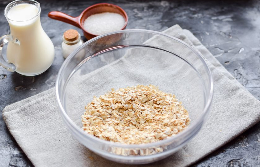 1. Этап. Овсянка без варки: Возьмите глубокую объемную миску, всыпьте в нее отмеренное количество овсяных хлопьев. Добавьте щепотку соли.