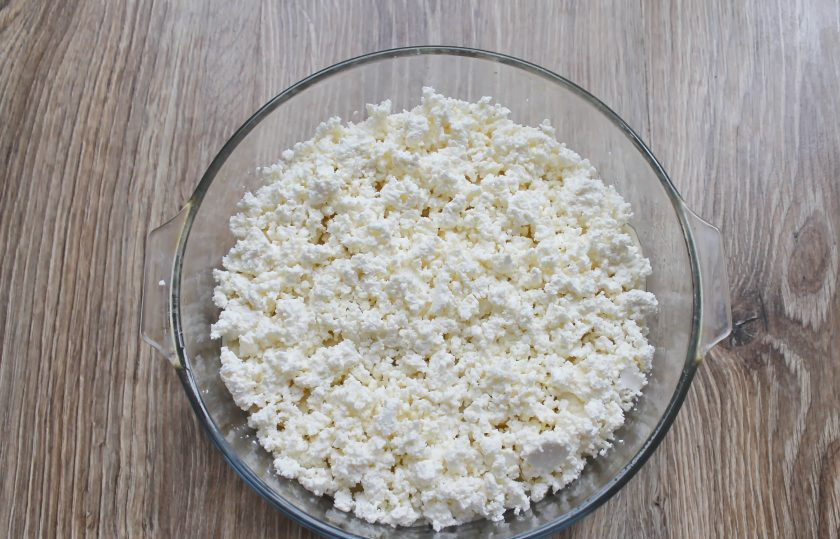 1. Этап. Картофель по-княжески: Поверх картофеля раскрошите творог. Все немного посолите и поперчите.