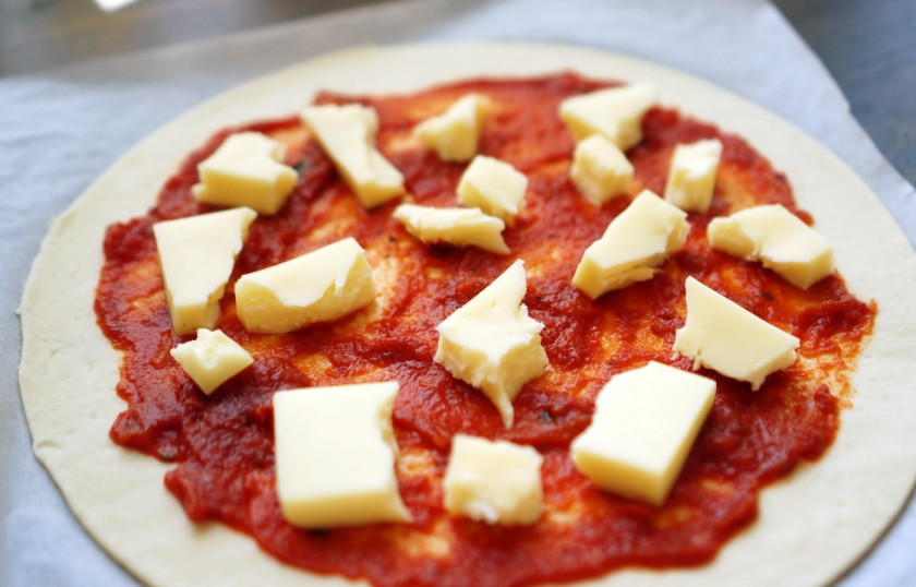 1. Этап. Пицца Маринара: Сыр моцарелла избавьте от жидкости и нарежьте довольно крупными кусочками. Затем равномерно распределите сыр по площади пиццы. Края оставьте свободными.