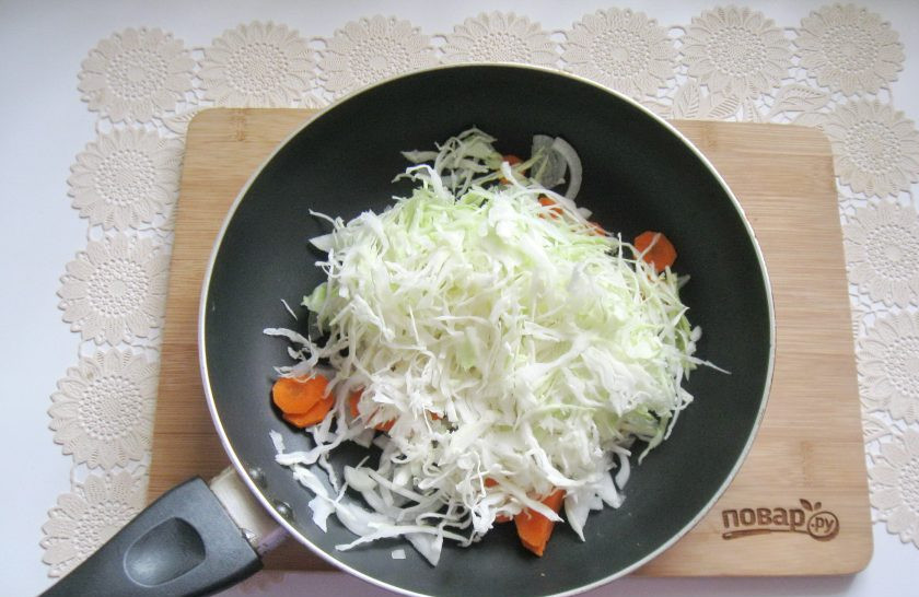 1. Этап. Капуста тушеная с курицей и грибами: Капусту нашинкуйте тонкой соломкой и добавьте к луку и моркови. Налейте подсолнечное масло и немного воды.