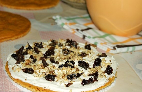 1. Этап. Торт Арлекин: 11. Теперь можно собирать тортик. Корж обильно смазать кремом и выложить на него немного измельченного чернослива и подсушенных орешков.