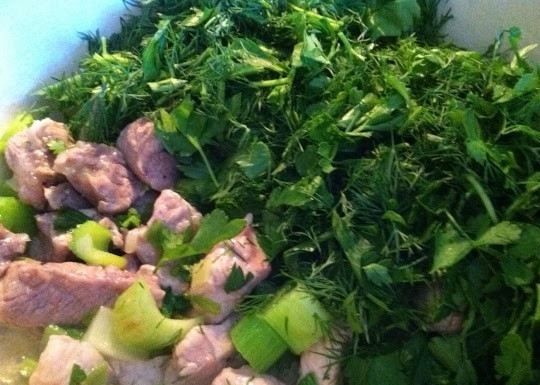 1. Этап. Свинина, тушенная с зеленью: Разогрейте масло и слегка обжарьте свинину, отправьте к ней лук и затем сельдерей. Через минуту всыпьте укроп с петрушкой.