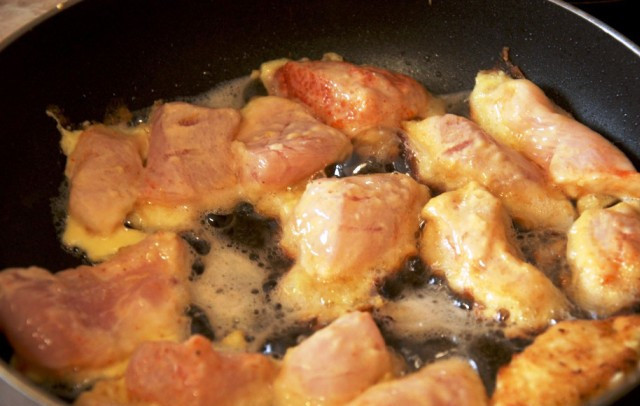 1. Этап. Куриные кусочки в яйце: Разогрейте на сковороде масло, и выложите на неё порцию мяса.