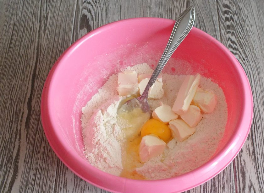 1. Этап. Печенье с ирисками: Добавьте яйцо, мягкое сливочное масло. Перемешайте и начните замес руками. Возможно в момент замеса понадобится еще мука. Добавляйте понемногу, пока тесто не станет мягким и эластичным.