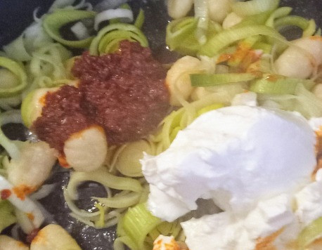 1. Этап. Ньокки с луком-пореем и харисой: В форму для запекания выложить лук- порей, ньокки, оливковое масло, крем-фреш, 4 чайных ложки харисы и соль. Перемешать.